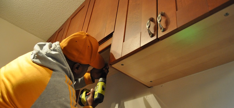 Handy man repairing cupboards