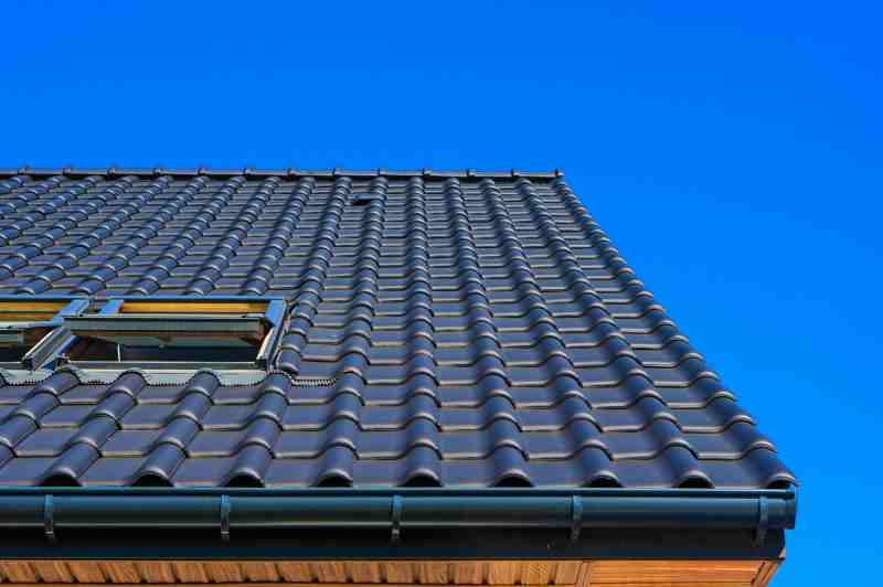 Modern black tile roof with skylight, showcasing smart solutions like cool roofs for better roofing and siding efficiency.
