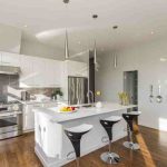 Modern kitchen with white cabinets and appliances, symbolizing a greener lifestyle and holistic sustainability.