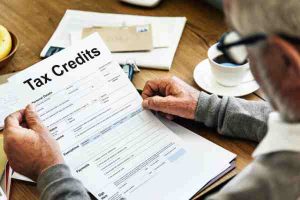 Person holding a tax credit form, symbolizing the use of green energy incentives for a sustainable future.
