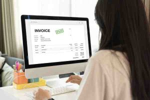Woman reviews a digital invoice to monitor utility bills for sustained home energy efficiency.